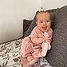 baby, bed, blanket, blue_eyes, child, cozy, cushion, cute, feet, hair_bow, happy, home, indoor, infant, person, pink_dress, plush_toy, portrait, sitting, smiling