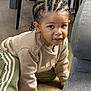 Sacha a rejoint le concours — aidez-le/la à gagner de superbes lots ! child, indoor, floor, crawling, braided_hair, sweatshirt, pants, adidas, beige, green, white_stripes, couch, table, wood_floor, person, young_child, casual_clothing, cute, portrait, home