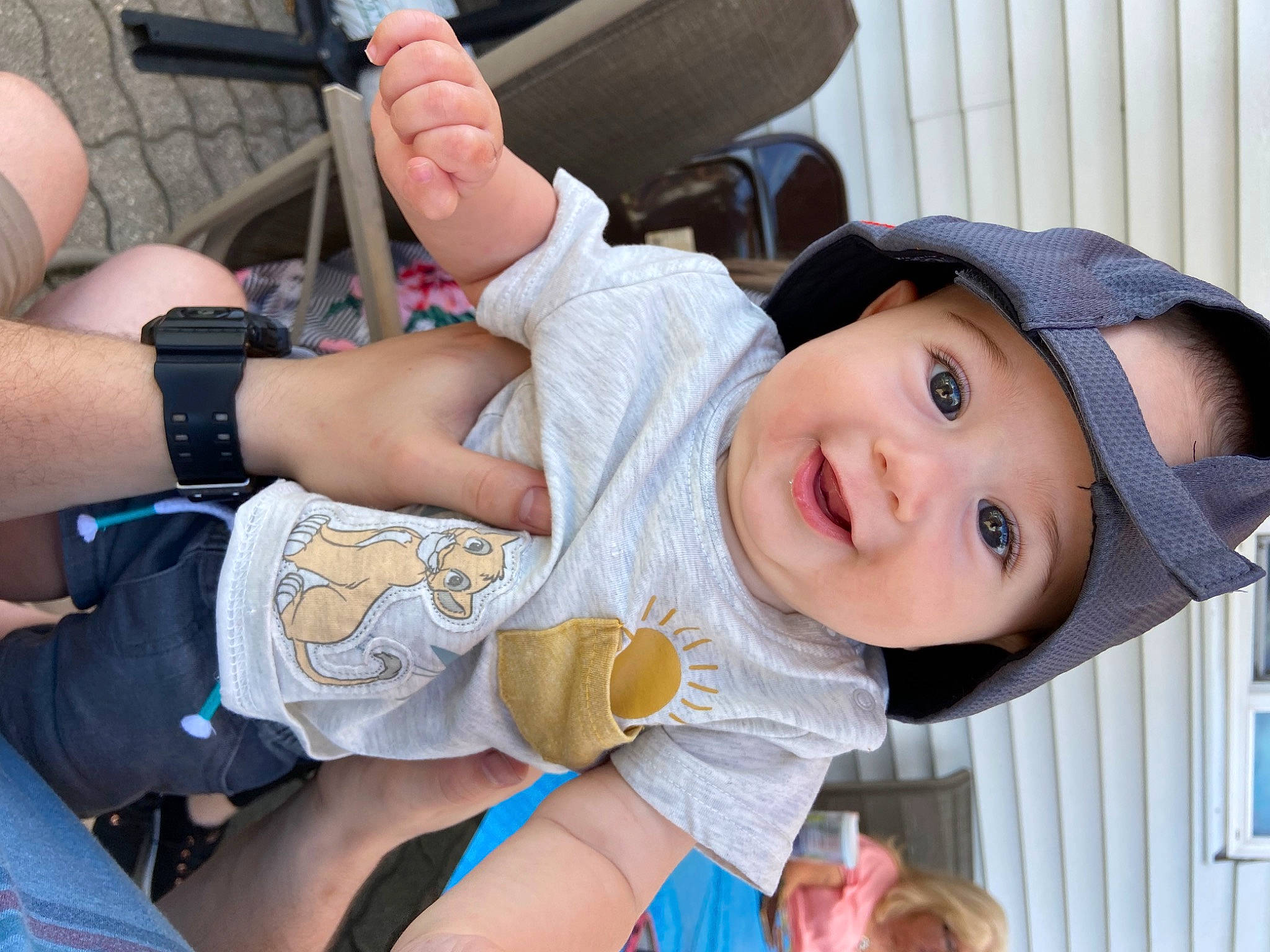 Keegan is registered to the contest to win money with this photo: arm, baby, baby_toddler_clothing, elbow, finger, fun, gesture, hand, happy, hat, headwear, human_leg, mouth, nail, person, skin, smile, sun_hat, thigh, thumb