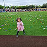Joelee joined the competition — help win amazing prizes! child, girl, pink_dress, grass, field, colorful, plastic_eggs, crowd, outdoor, playful, smiling, event, people, overcast_sky, fun, celebration, young, boots, greenery, joy