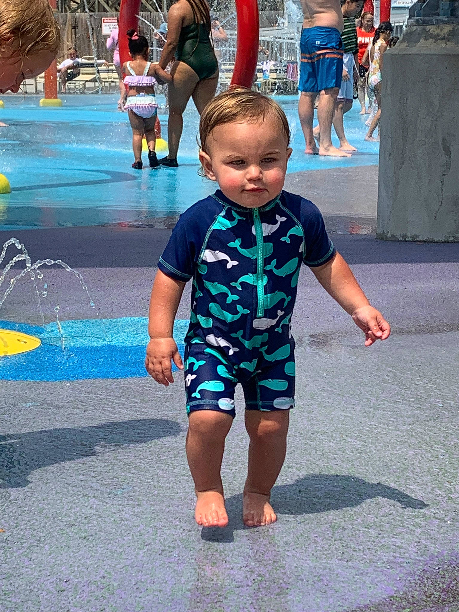 Brantley is registered to the contest to win money with this photo: asphalt, barefoot, child, event, eyewear, foot, fun, gesture, happy, human_leg, leg, leisure, pedestrian, person, recreation, road, shorts, sidewalk, t_shirt, toddler