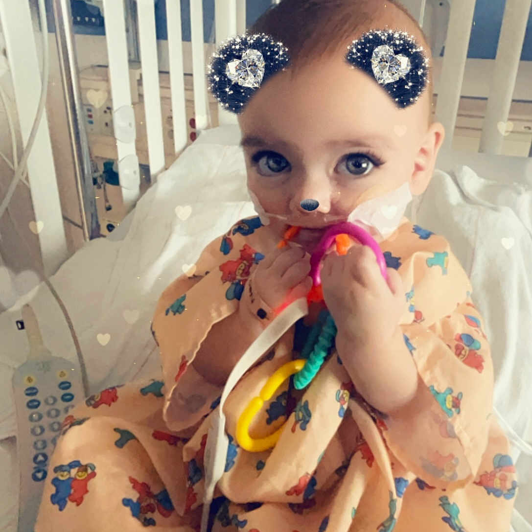 Hazel is registered to the contest to win money with this photo: accessories, architecture, bed, building, clothing, crib, cutlery, dress, face, furniture, head, homedecor, hospital, indoors, infantbed, person, photography, portrait, spoon, toy