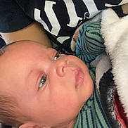 Xykie is registered to the contest to win money with this photo: baby, infant, blanket, striped_clothing, face, person, skin, head, portrait, closeup, child, cuddle, warm, resting, soft, newborn, young, expression, comfort, indoor