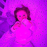 Eliana-Rose is registered to the contest to win money with this photo: baby, bottle, crib, plush_bunny, sleepwear, child, blue_eyes, sheet, pattern, moon, stars, lying_down, indoor, toy, feeding, cute, infant, sleepy, purple_lighting, cozy