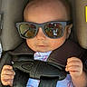 baby, child, sunglasses, car_seat, harness, baseball_print, onesie, infant, seatbelt, reflection, cool, cute, hands, casual, portrait, indoors, fashion, headwear, person, young