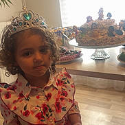 Lylia a rejoint le concours — aidez-le/la à gagner de superbes lots ! child, girl, tiara, crown, dress, floral, red_skirt, curly_hair, indoor, cake, dolls, table, flooring, window, natural_light, party, celebration, food, birthday, portrait