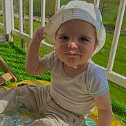 Aurélien a rejoint le concours — aidez-le/la à gagner de superbes lots ! toddler, child, hat, sunhat, outdoor, greenery, playmat, grass, balcony, railing, pants, shirt, smile, face, hand, sunlight, daylight, nature, baby, portrait