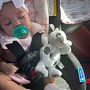 Charlotte joined the competition — help win amazing prizes! baby, child, car_seat, pacifier, headband, sleeping, toy, stuffed_animal, blanket, pink_clothing, socks, seatbelt, car_interior, sunlight, peaceful, infant, cute, cozy, soft_toy, resting