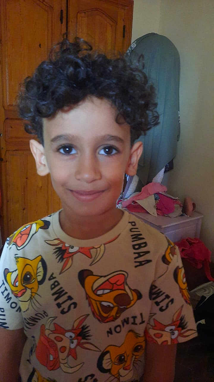 Amir a rejoint le concours — aidez-le/la à gagner de superbes lots ! child, boy, curly_hair, smiling, shirt, lion_king, indoor, wardrobe, clothing, furniture, face, person, portrait, happy, young, cute, room, casual, colorful, hair