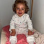 toddler, child, curly_hair, blue_eyes, white_outfit, hearts_pattern, pink_towel, sitting, indoors, smiling, happy, cozy, blanket, clothing, person, portrait, cute, baby, feet, hands