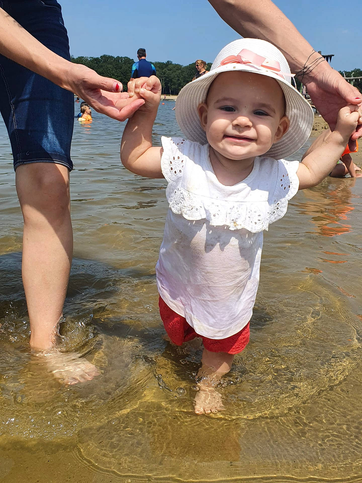 Anaïs participe au concours pour gagner de l'argent avec cette photo : barefoot, beach, fun, gesture, hand, happy, hat, headwear, joy, lake, leisure, people_in_nature, people_on_beach, person, recreation, sand, shorts, sky, smile, t_shirt