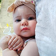 éléna a rejoint le concours — aidez-le/la à gagner de superbes lots ! baby, child, face, headband, bow, blanket, skin, arm, hand, portrait, closeup, expression, cute, infant, outdoor, soft_light, clothing, young, person, newborn