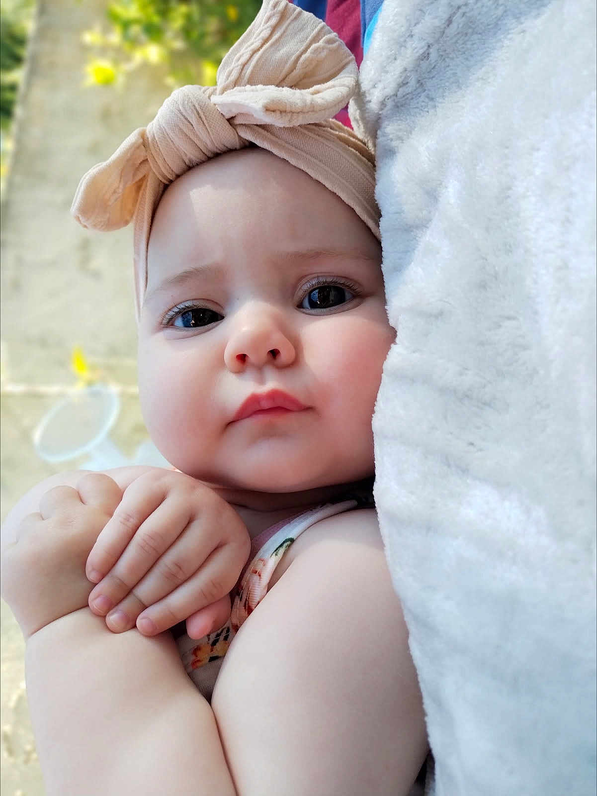 éléna a rejoint le concours — aidez-le/la à gagner de superbes lots ! baby, child, face, headband, bow, blanket, skin, arm, hand, portrait, closeup, expression, cute, infant, outdoor, soft_light, clothing, young, person, newborn