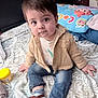 Eduardo is registered to the contest to win money with this photo: toddler, child, indoor, bed, jeans, shirt, jacket, socks, sandals, face, cute, expression, pillow, pattern, furniture, home, person, clothing, toy, curious