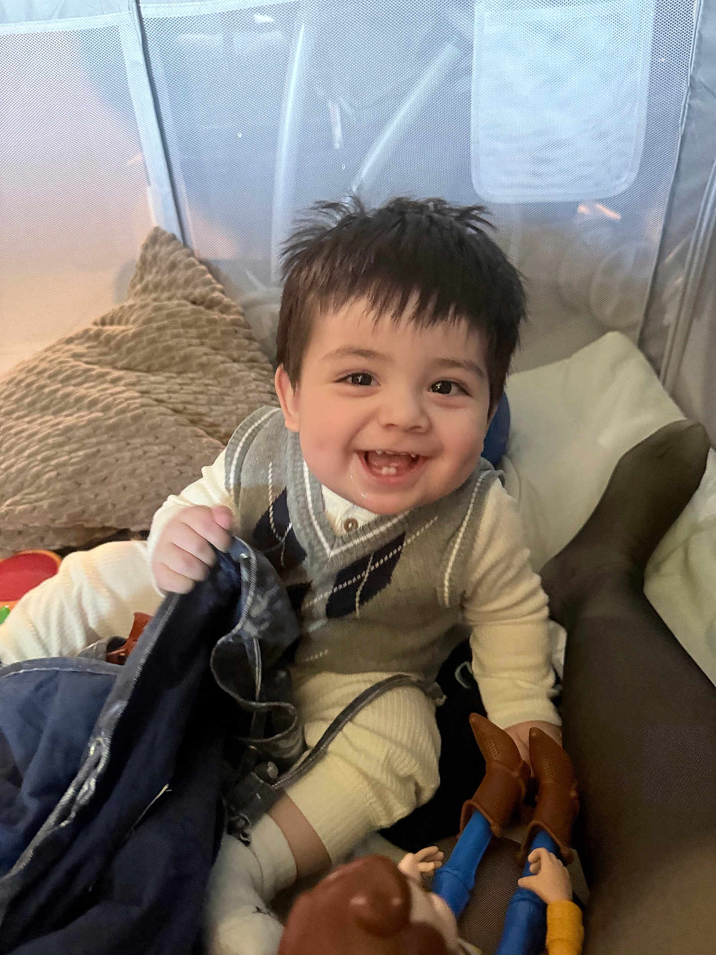 Eduardo is registered to the contest to win money with this photo: baby, child, clothing, cowboy, cushion, cute, doll, expression, face, hair, happy, indoor, infant, person, pillow, play, sitting, smiling, sweater, toy