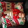 Malakai joined the competition — help win amazing prizes! baby, child, smile, winking, pajamas, blanket, christmas, holiday, festive, red, white, green, indoor, cozy, infant, cute, lying_down, toy, face, celebration