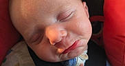 Josef joined the competition — help win amazing prizes! newborn, baby, sleeping, infant, face, portrait, car_seat, harness, seat_belt, red_cushion, cozy, indoors, close_up, peaceful, resting, clothing, blanket, safety_buckle, head, photography