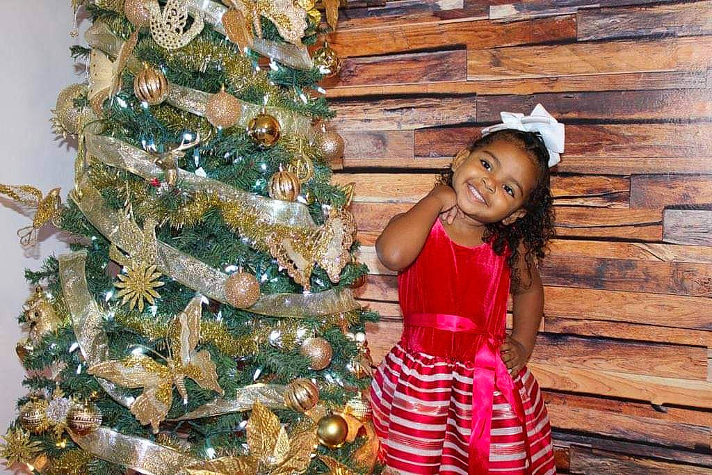 Leilani is registered to the contest to win money with this photo: child, christmas_decoration, christmas_ornament, christmas_tree, conifer, dress, event, evergreen, fun, happy, holiday, holiday_ornament, joy, ornament, people, people_in_nature, person, standing, toddler, tradition