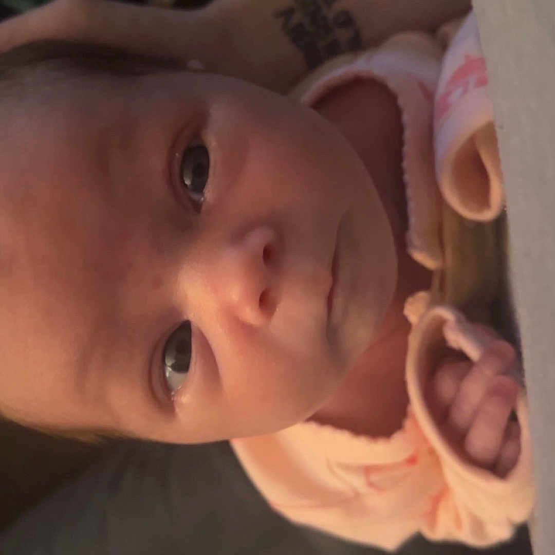 Andi is registered to the contest to win money with this photo: baby, closeup, clothing, cute, face, hand, holding, human, indoor, infant, newborn, newborn_baby, parent, person, portrait, skin, sleeve, soft_lighting, tattoo, young