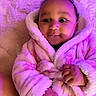 baby, infant, robe, pink, fluffy, soft, hand, face, curly_hair, blanket, closeup, cute, portrait, child, indoor, warm, cozy, expression, person, newborn