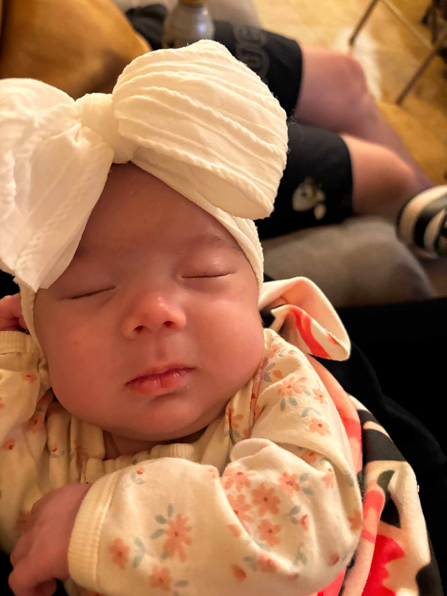Mila is registered to the contest to win money with this photo: baby, sleeping, headband, bow, floral_outfit, blanket, infant, closeup, peaceful, soft_lighting, person, indoor, cozy, cute, newborn, portrait, child, resting, warm, comfort