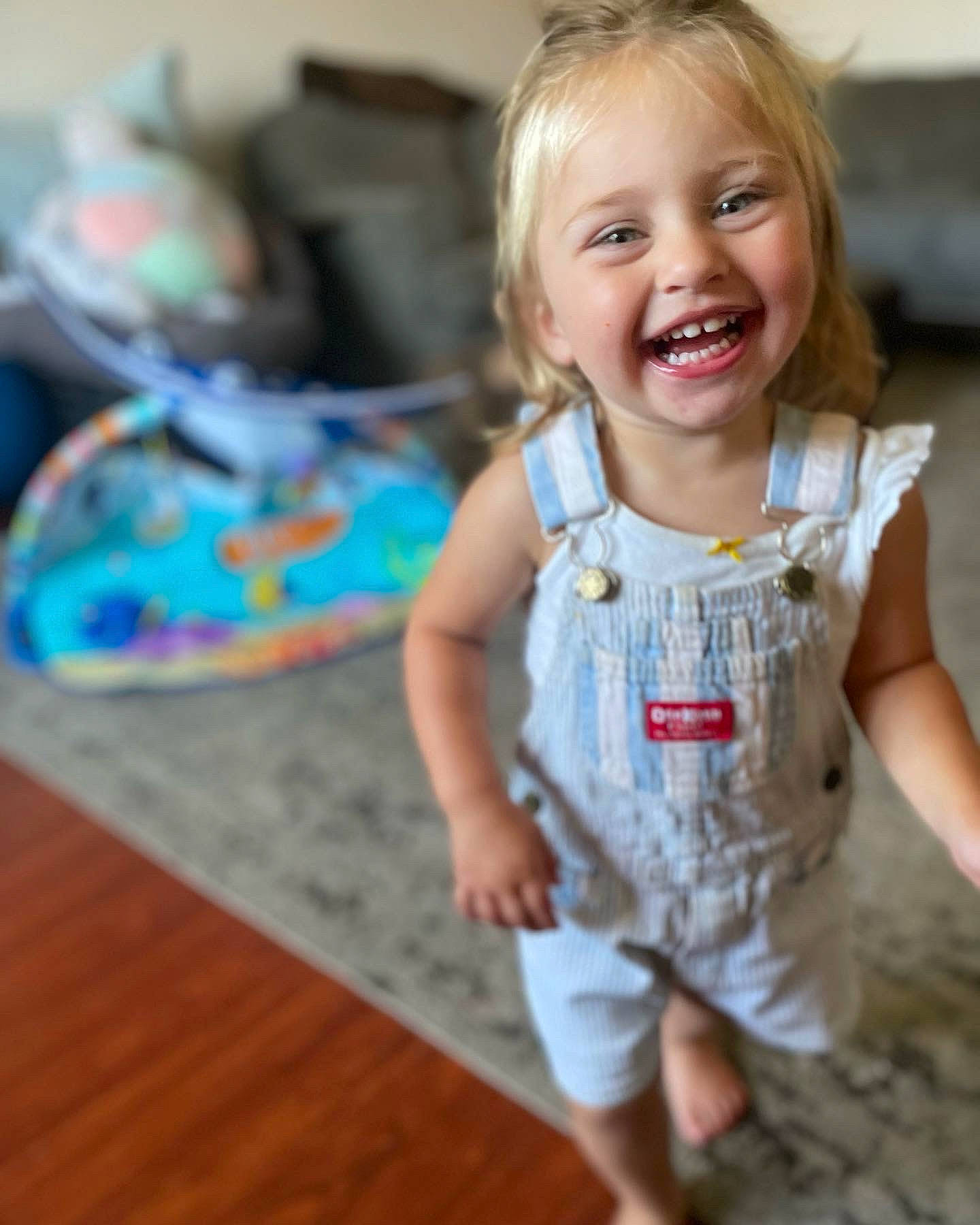 Josie is registered to the contest to win money with this photo: baby, baby_toddler_clothing, blond, cheek, face, flooring, fun, hair, hairstyle, happy, head, joy, leisure, person, shorts, sitting, skin, sleeve, smile, t_shirt