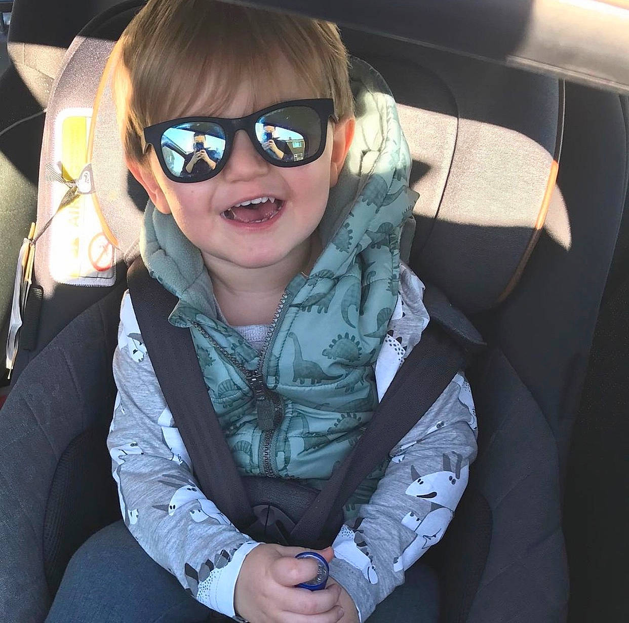 Edison is registered to the contest to win money with this photo: auto_part, car_seat, cool, eyewear, finger, gesture, glasses, goggles, hand, happy, head_restraint, person, personal_protective_equipment, selfie, sleeve, smile, sunglasses, thumb, toddler, vehicle_door