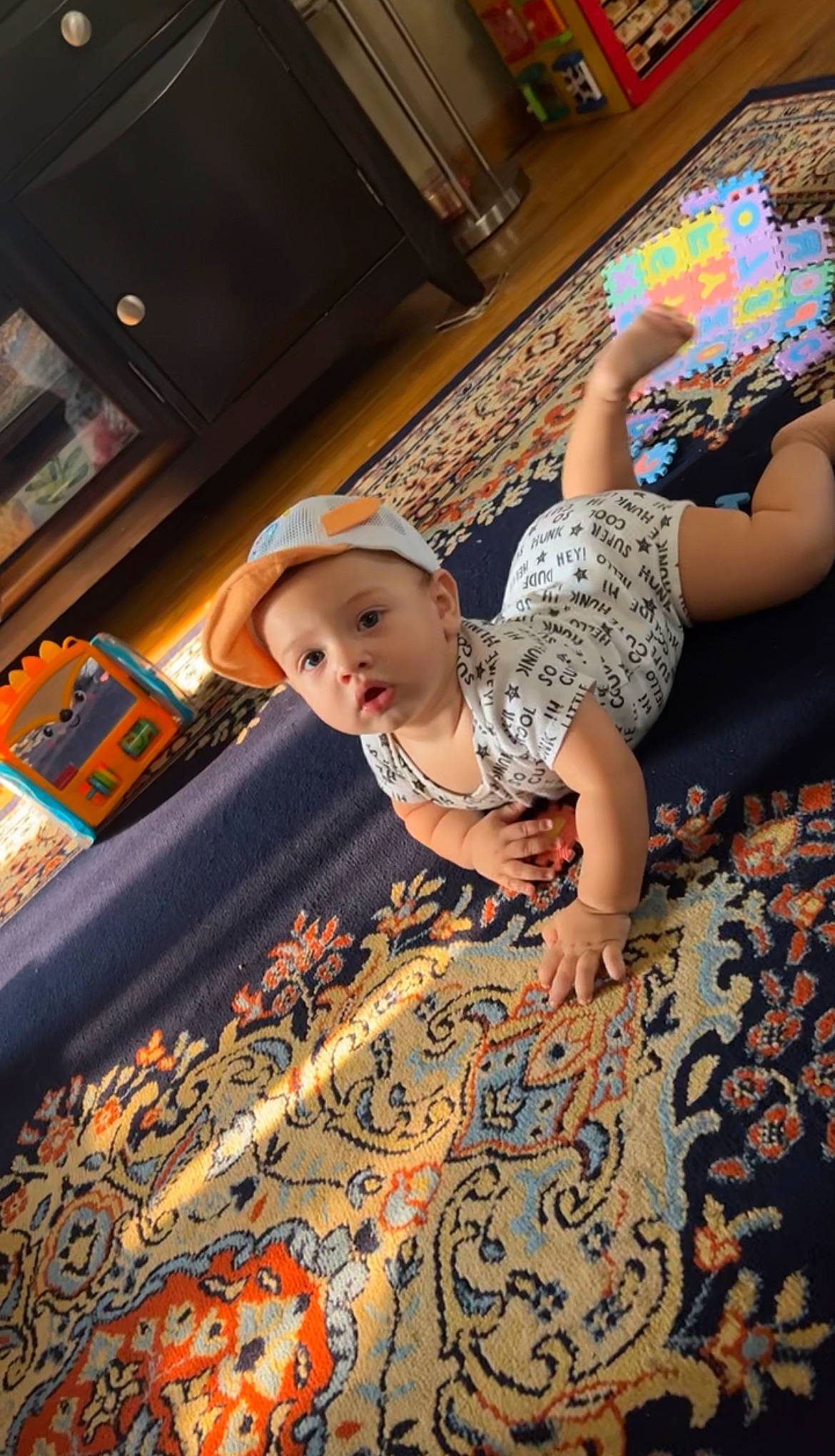 Xaviel joined the competition — help win amazing prizes! baby, carpet, child, flash_photography, floor, flooring, fun, happy, headwear, human_leg, knee, leisure, pattern, person, room, shelf, sitting, t_shirt, thigh, toddler