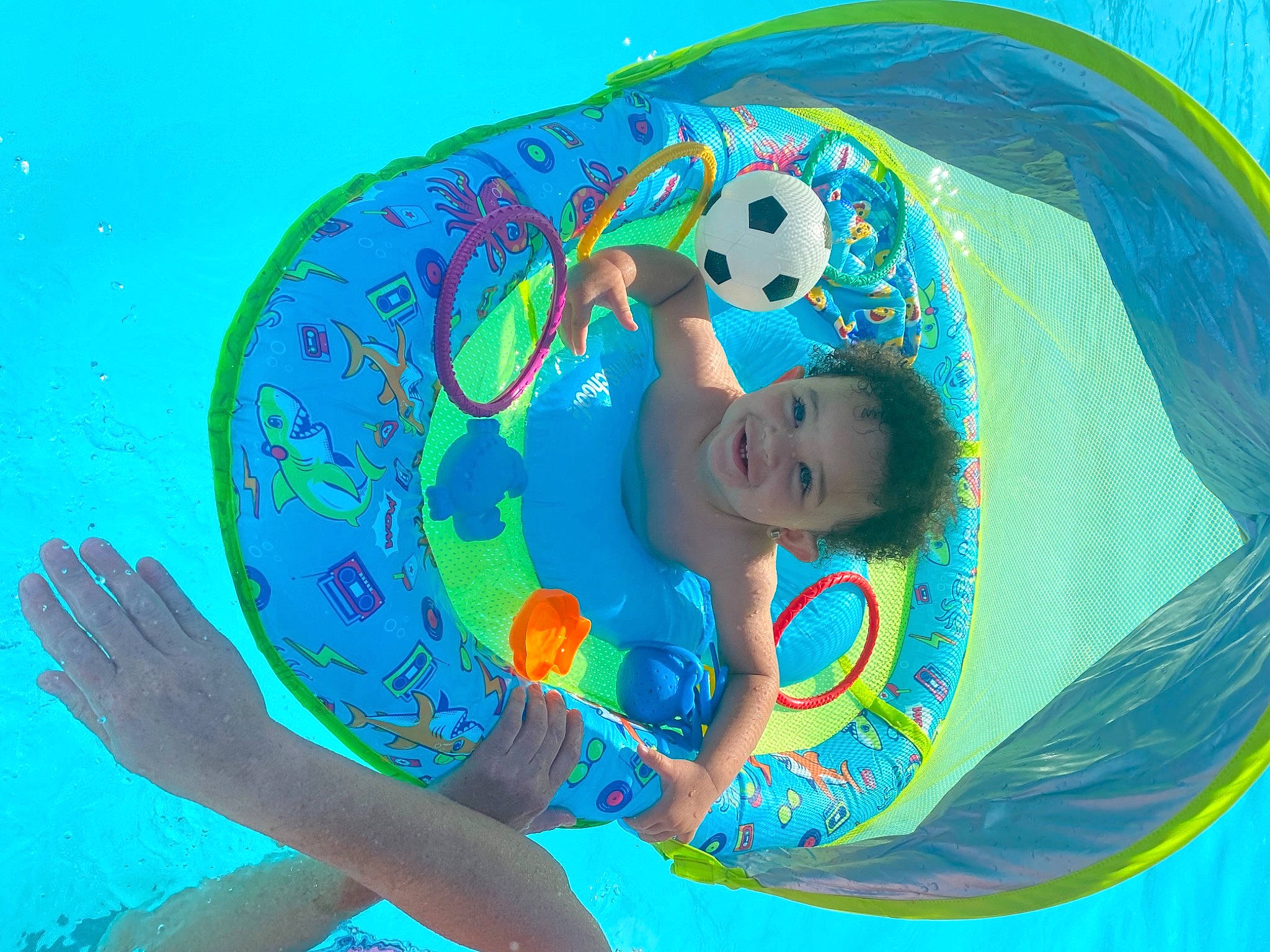 Donovan is registered to the contest to win money with this photo: aqua, art, azure, baby, baby_float, baby_toddler_clothing, bathing, child, circle, electric_blue, fun, happy, joy, leisure, people_in_nature, person, play, recreation, summer, swimming_pool