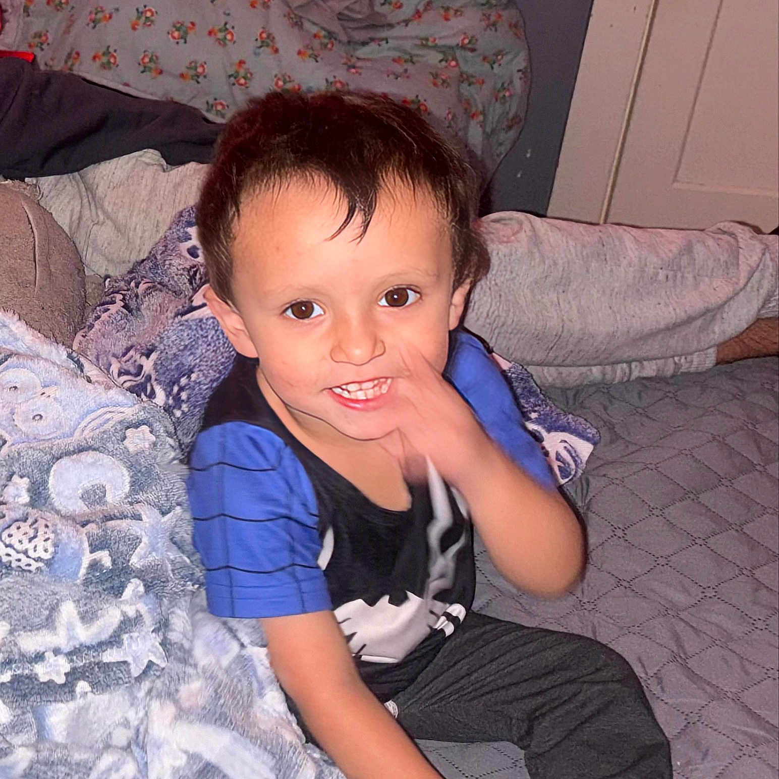 Zyler joined the competition — help win amazing prizes! bed, blanket, brown_hair, casual_clothing, child, comfort, cozy, face, furniture, hand, happy, indoor, pants, person, room, sitting, smiling, sock, soft, young