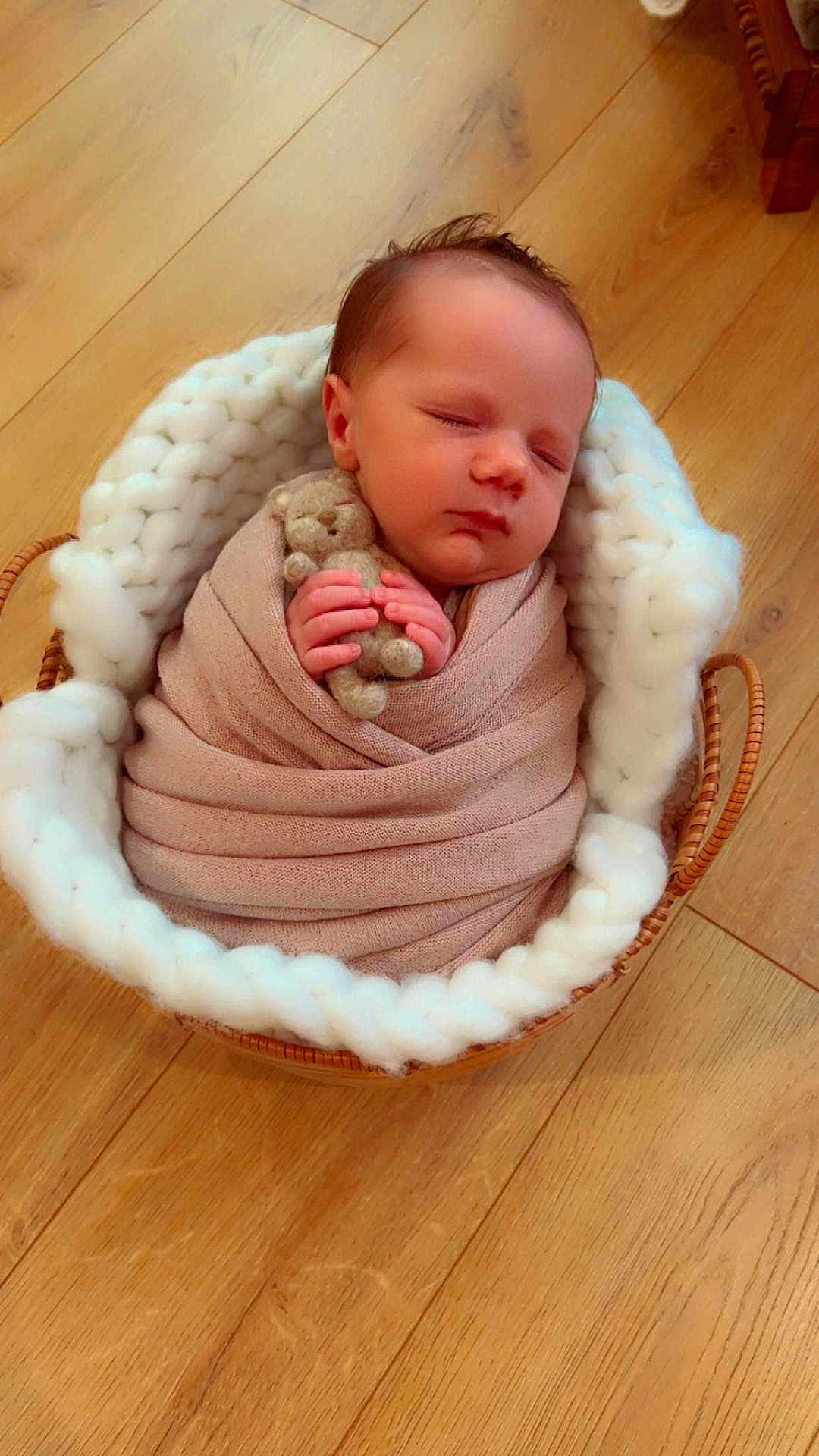 Swan a rejoint le concours — aidez-le/la à gagner de superbes lots ! newborn, baby, sleeping, swaddled, blanket, teddy_bear, basket, knit, wooden_floor, infant, peaceful, cute, hand, face, portrait, indoors, soft_texture, resting, cozy, child