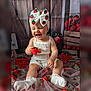 baby, child, smiling, white_clothing, headband, bow, strawberry, toy, sitting, decorations, fabric, cute, happy, indoor, portrait, sock, playful, wood_background, red, green