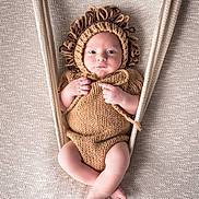 Pablo a rejoint le concours — aidez-le/la à gagner de superbes lots ! baby, infant, knitted, lion_costume, hammock, beige, soft_texture, cute, portrait, wide_eyes, baby_clothing, hand_knitted, cozy, comfortable, newborn, child, resting, fabric, background, baby_pose