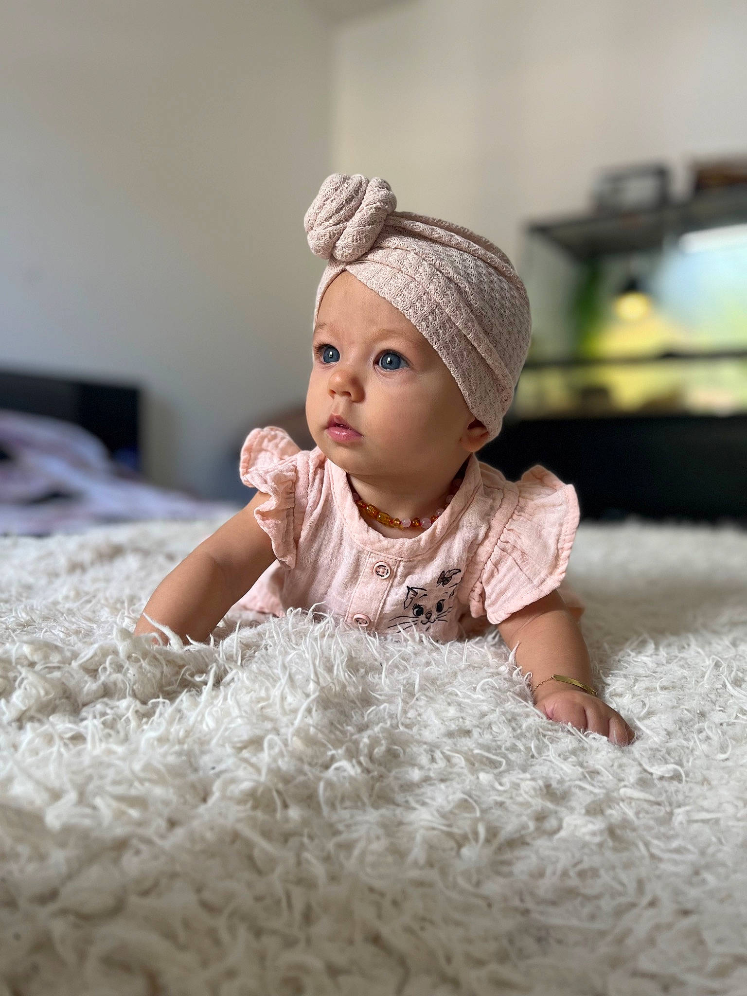 Joy a rejoint le concours — aidez-le/la à gagner de superbes lots ! baby, baby_toddler_clothing, cap, child, comfort, eye, face, fashion_accessory, flash_photography, flooring, fur, happy, headgear, headwear, knit_cap, linens, person, sitting, skin, toddler
