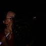 child, person, glasses, darkness, night, stick, holding, face, hair, closeup, embrace, red_clothing, illumination, shadow, outdoor, intimacy, parent, childhood, together, love