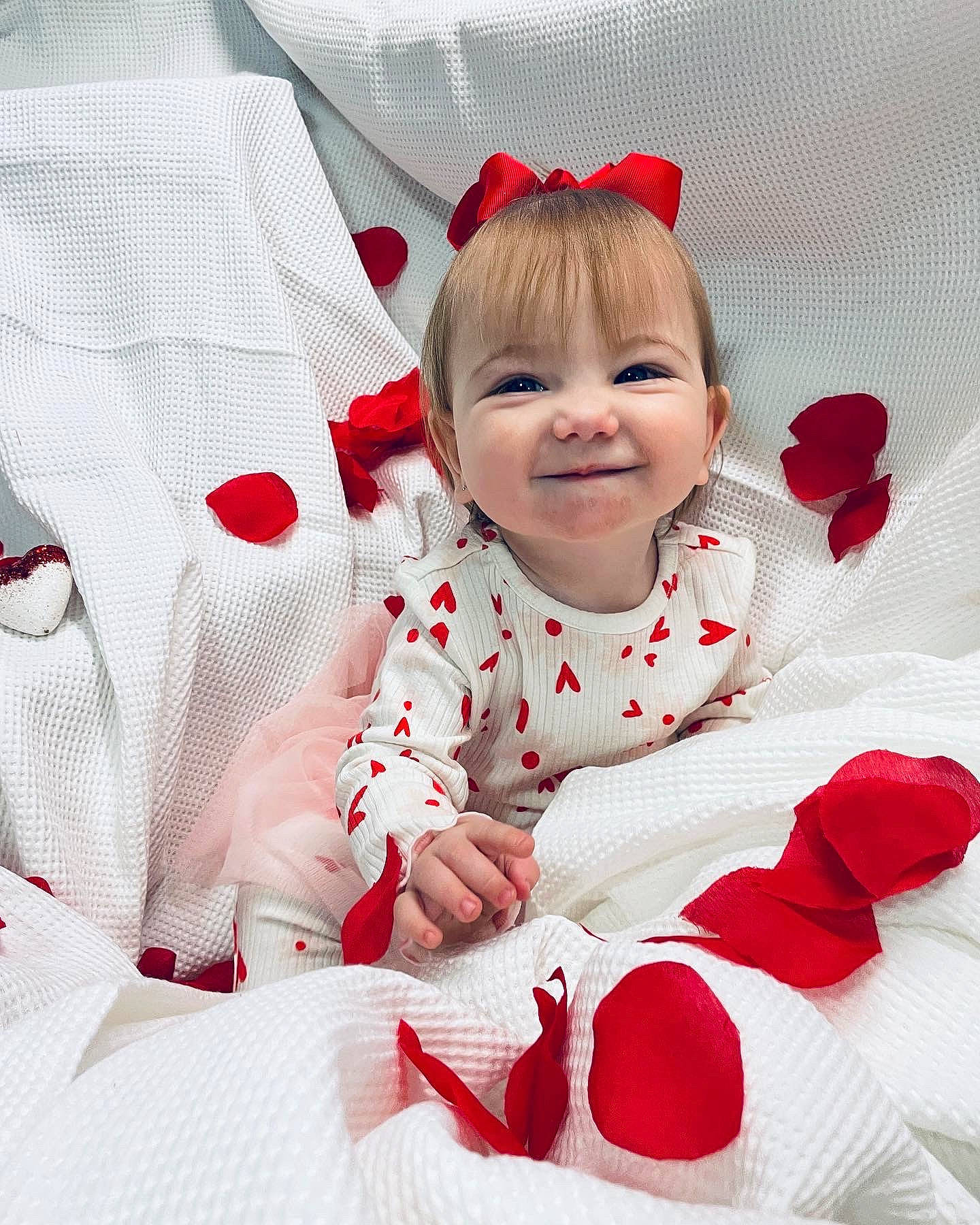 Isla is registered to the contest to win money with this photo: baby, baby_toddler_clothing, carmine, child, comfort, dress, event, happy, joy, linens, pattern, person, petal, plant, product, red, rose_family, sleeve, smile, textile