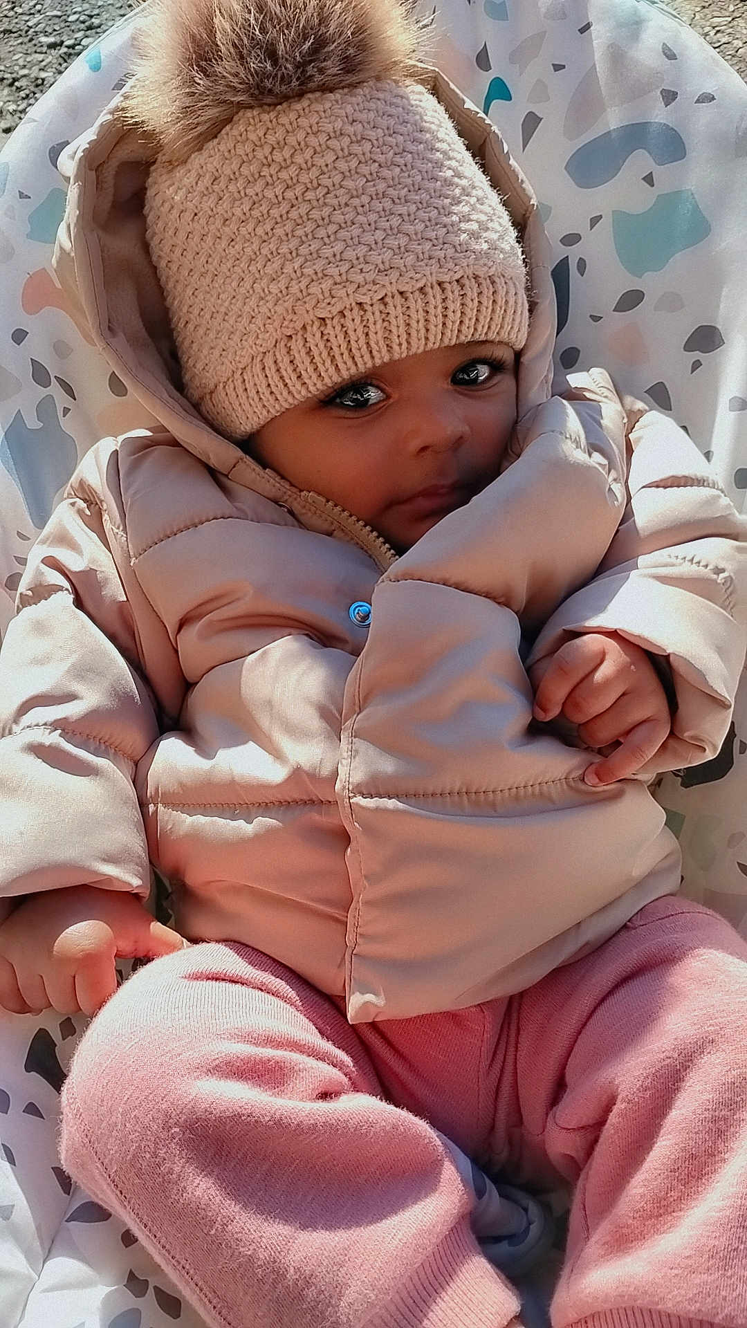 Mylee Millsaps joined the competition — help win amazing prizes! baby, child, puffy_jacket, knitted_hat, pom_pom, pink_pants, baby_seat, patterned_seat, outdoor, cold_weather, cute, portrait, infant, warm_clothing, small_hands, cozy, looking_at_camera, soft_texture, winter_wear, young_child