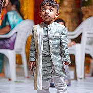 Advait joined the competition — help win amazing prizes! child, toddler, boy, portrait, traditional_clothing, formalwear, wedding, celebration, standing, looking_up, serious_expression, blue_shoes, ornate_outfit, scarf, indoor, decorations, plastic_chairs, guests, colorful_background, photography