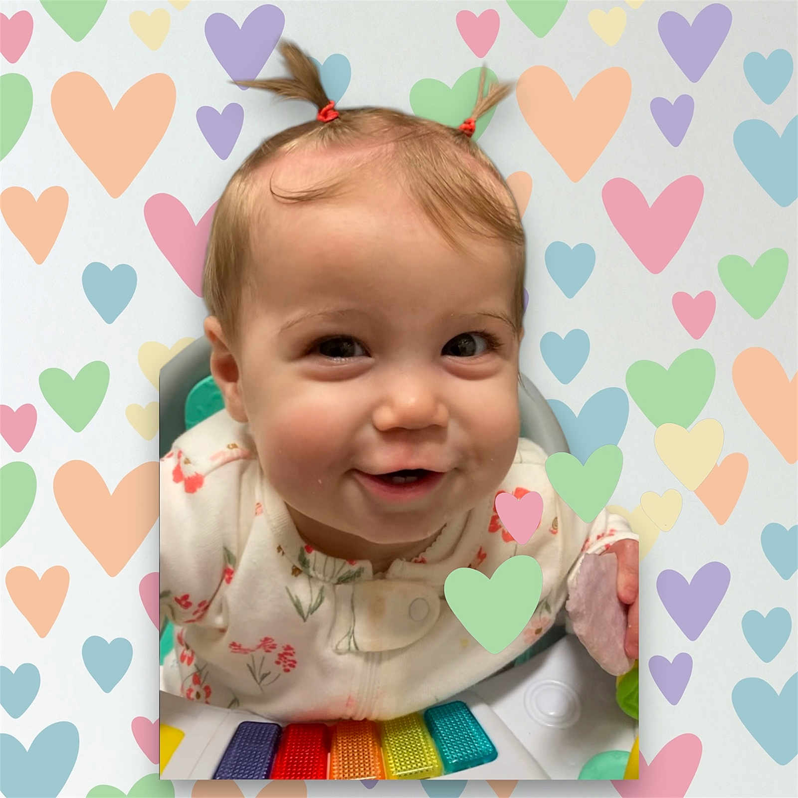 Darla is registered to the contest to win money with this photo: baby, child, smiling, pigtails, activity_center, colorful, heart_pattern, cute, infant, playful, portrait, indoors, happy, young_child, face, clothing, toy, closeup, cheerful, person