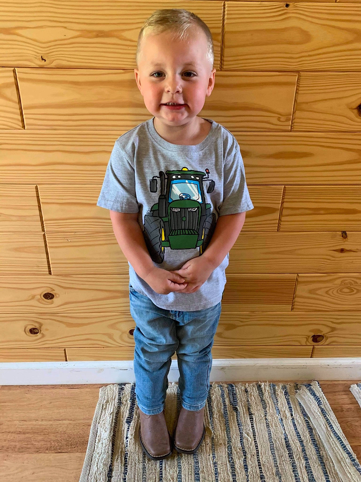 Easton is registered to the contest to win money with this photo: baby_toddler_clothing, child, clothing, denim, floor, flooring, happy, hardwood, head, leg, person, plank, sleeve, smile, standing, t_shirt, toddler, varnish, waist, wood
