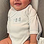 baby, smiling, onesie, infant, cushion, child, cute, happy, skin, seat, hand, legs, indoor, portrait, face, clothing, young, babywear, comfort, expression