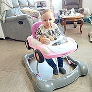 Anna a rejoint le concours — aidez-le/la à gagner de superbes lots ! baby, walker, toy_car, striped_shirt, lacy_collar, navy_pants, hearts_pattern, socks, living_room, sofa, armchair, coffee_table, flooring, furniture, indoor, child, person, home, curious, seated