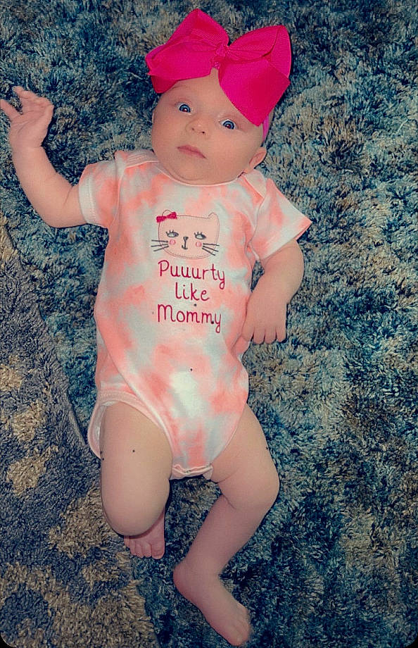 Aubrey is registered to the contest to win money with this photo: baby, baby_toddler_clothing, blue, cap, carmine, child, electric_blue, finger, fun, grass, happy, headgear, headwear, human_leg, person, personal_protective_equipment, pink, skin, sleeve, standing