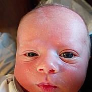 William is registered to the contest to win money with this photo: baby, newborn, face, skin, eyes, clothing, button, portrait, infant, cute, expression, closeup, person, young, head, babywear, soft, newborn_clothing, indoors, human