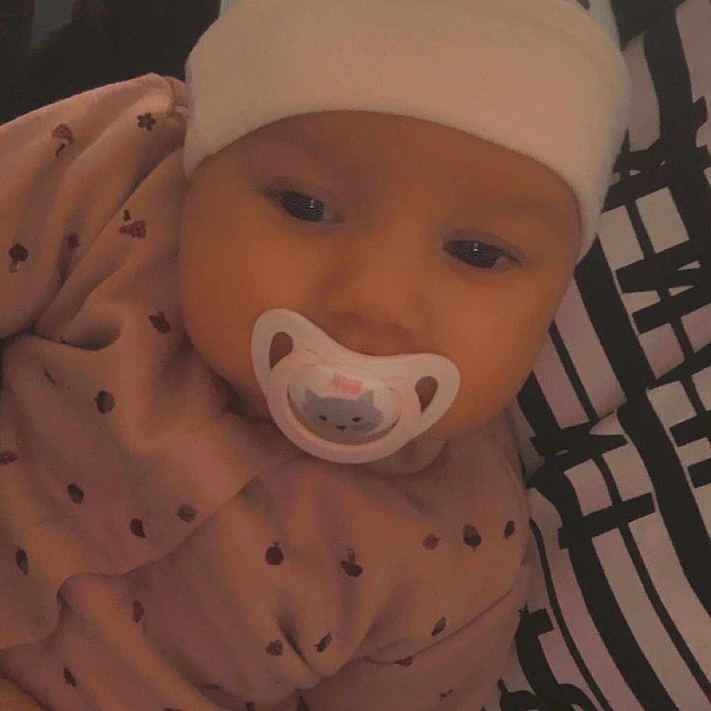 Giuliana a rejoint le concours — aidez-le/la à gagner de superbes lots ! adorable, baby, child, closeup, cute, face, hand, hat, holding, indoor, infant, newborn, pacifier, person, pink_clothing, resting, sleepy, soft_light, striped_shirt, warm