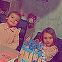 child, birthday_cake, cake, cartoon_characters, celebration, table, chair, wall, photo_frame, smile, girl, party, indoor, decorations, food, happy, person, cute, home, family