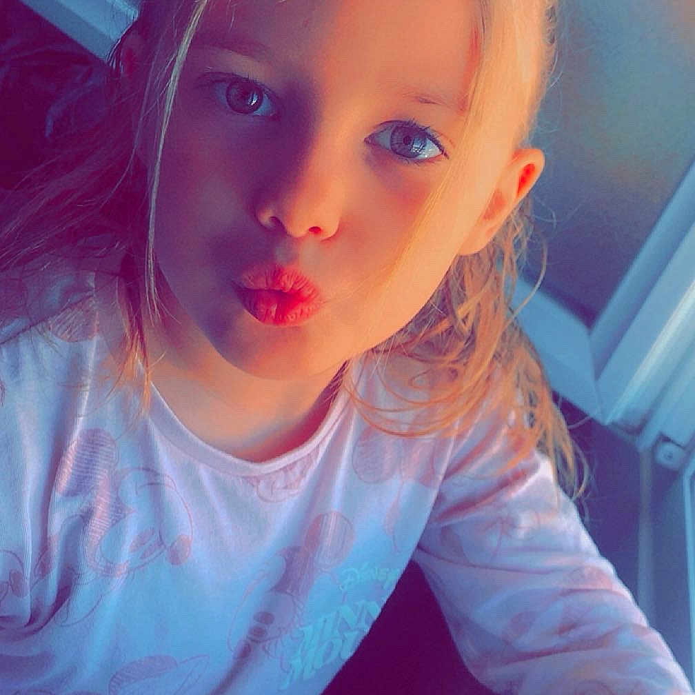 Méliana a rejoint le concours — aidez-le/la à gagner de superbes lots ! blonde_hair, blue_eyes, casual_clothing, child, closeup, cute, face, girl, hair_tied_back, indoor, light, long_sleeve_shirt, mickey_mouse, person, playful, portrait, pout, sunlight, window, young