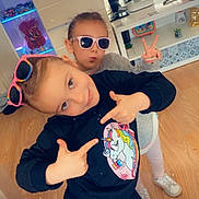 Méliana a rejoint le concours — aidez-le/la à gagner de superbes lots ! child, kids, indoor, sunglasses, unicorn, sweatshirt, playing, pose, peace_sign, floor, wooden_floor, tv_screen, video_game, toys, shelf, casual_clothing, smile, fun, home, person