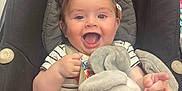 Nino participe au concours pour gagner de l'argent avec cette photo : baby, child, car_seat, sunglasses, heart_shaped, stuffed_animal, bunny, toy, smiling, happy, clothing, striped_shirt, seatbelt, indoor, person, cute, infant, playful, young, portrait