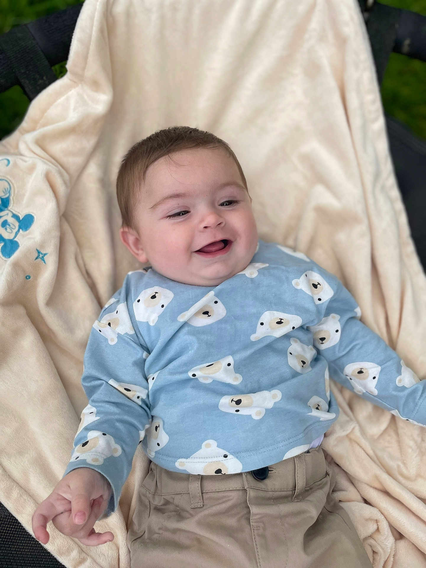 Nino participe au concours pour gagner de l'argent avec cette photo : baby, child, smiling, blanket, blue_shirt, polar_bear_pattern, pants, beige, happy, face, infant, cute, clothing, lying_down, outdoor, soft_texture, portrait, skin, hand, head